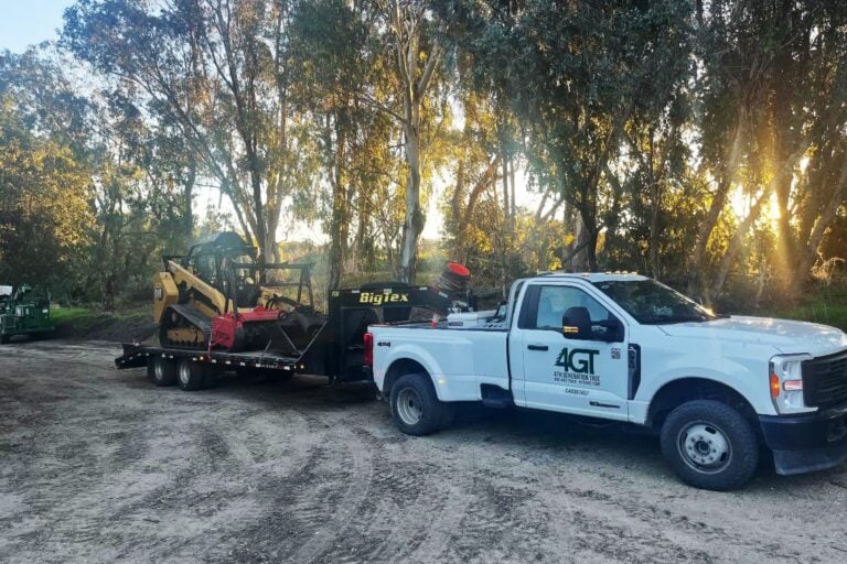 4th Generation Tree pickup towing a trailer loaded with compact equipment.